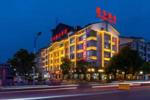 un bâtiment avec des panneaux de néon sur son côté dans l'établissement Yiwu Defeng Hotel, à Yiwu