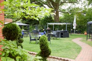 a park with tables and chairs in the grass at Gästehaus am Landhaus Friedrichsfehn in Edewecht