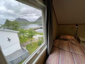 a bedroom with a window with a bed and a view at Old fisherman's house with 4 bedroom in Gryllefjord