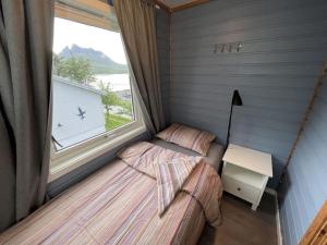 a bedroom with two twin beds and a window at Old fisherman's house with 4 bedroom in Gryllefjord