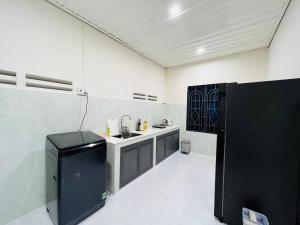 una cocina con electrodomésticos en blanco y negro en una habitación en Charis Home- Tay Ninh en Tây Ninh