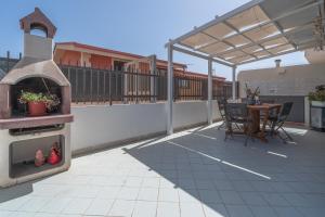 eine Außenterrasse mit einem Pizzaofen und einem Tisch in der Unterkunft Andromeda Luxury Home in Portopalo