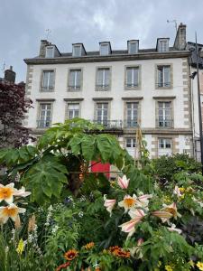 a large building with flowers in front of it at hotel de Croix in Morlaix