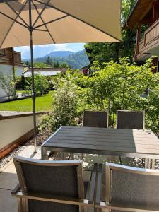 einen Tisch und Stühle mit Sonnenschirm auf einer Terrasse in der Unterkunft Palais Karl-Theodor in Rottach-Egern