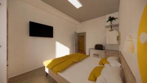 a bedroom with a bed with a yellow blanket on it at Hotel Active Stadium in Lovosice