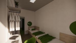 Habitación con 2 camas y escritorio con sillas verdes. en Hotel Active Stadium en Lovosice