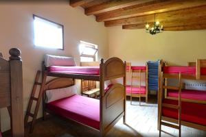 a room with four bunk beds and a window at Albergue El Puntido in Hontanas