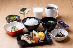 une table avec des plaques alimentaires et un verre de lait dans l'établissement Hotel KAN-RAKU Akita Kawabata, à Akita