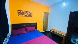 una camera con un letto e una parete gialla di Grand Cabin Pinnawala a Rambukkana