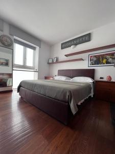 - une chambre avec un grand lit et du parquet dans l'établissement Casa vacanze Attico sul lago di Lecco, a due passi dal centro con posto auto, à Lecco