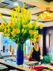 un vase rempli de fleurs jaunes sur une table dans l'établissement Moonlight Hotel Hue, à Hue