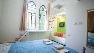 a bedroom with a blue bed and a ladder at Villa Marina in Haifa