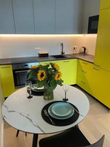 a kitchen with a table with a vase of sunflowers at Haki Apartment in Tartu