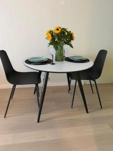a table with two chairs and a vase of flowers at Haki Apartment in Tartu