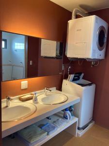 a bathroom with two sinks and a large mirror at ＰＥＮＳＩＯＮ　ＳＨＩＭＡＫＡＺＥ in Motobu