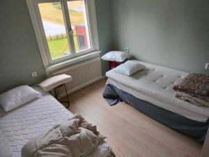 1 dormitorio con 2 camas y ventana en Vackert naturnära i Höga Kusten 
