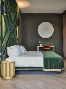1 dormitorio con 1 cama grande y pared verde en Boutique Hotel Stresa en Stresa