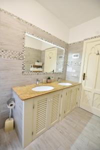 un bagno con due lavandini e un grande specchio di Villa Sunshine Positano Room a Positano