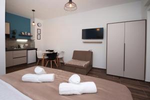 - une chambre avec un lit et 2 serviettes blanches dans l'établissement P&P Apartmans Drapić, à Trebinje