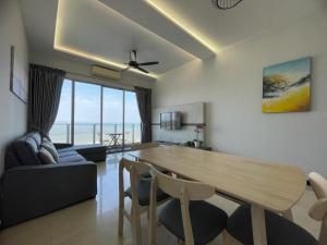 a living room with a wooden table and a couch at Silverscape,Res -- Seaview -- Balcony -- 7 pax in Melaka