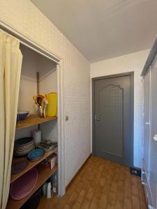 une chambre avec une porte s'ouvrant sur une cuisine avec des assiettes dans l'établissement Appartement en Rez de Villa Beausite, à Mandelieu-la-Napoule