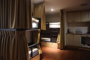 新竹市にあるエルメス ホテルの二段ベッド2台とキッチンが備わる客室です。