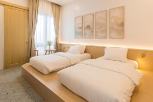 a bedroom with two beds and a window at The Elements Boutique House in Phuket Town