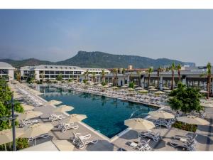 a large swimming pool with chairs and umbrellas at Swandor Hotels & Resorts - Kemer in Kemer