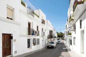 a car parked on a street between two buildings at Reina's in Vejer de la Frontera