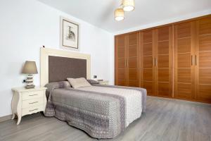 a bedroom with a bed and a wooden cabinet at Reina's in Vejer de la Frontera