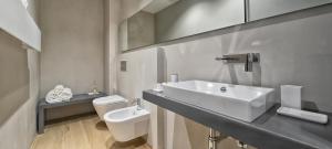 a white bathroom with a sink and a toilet at Luxury Suites Collection - SHANTUNG Double Room in Riccione