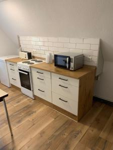 uma cozinha com um balcão com um micro-ondas e um fogão em Monteurwohnungen Visselhövede em Visselhövede