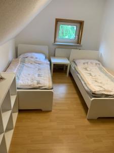 um quarto com 2 camas, uma mesa e uma janela em Monteurwohnungen Visselhövede em Visselhövede