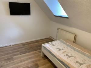 um quarto com uma cama e uma televisão na parede em Monteurwohnungen Visselhövede em Visselhövede