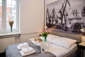 ein Zimmer mit einem Bett und einem Tisch mit Blumen darauf in der Unterkunft Maya's Flats & Resorts 63 - 3 rooms flat in old town Gdansk in Danzig