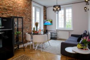 a living room with a brick wall and a blue couch at Maya's Flats & Resorts 63 - 3 rooms flat in old town Gdansk in Gdańsk
