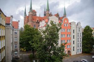 eine Reihe von Gebäuden in einer Stadt mit einem Schloss in der Unterkunft Maya's Flats & Resorts 63 - 3 rooms flat in old town Gdansk in Danzig