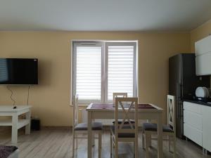 a kitchen with a table and chairs and a window at Apartament Rodzinny in Oława