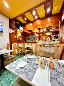 a dining room with a table and chairs and a restaurant at Hotel Fiorella Milano in Milan