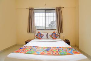 sypialnia z dużym łóżkiem i oknem w obiekcie FabHotel Mountain High Inn w mieście Pune
