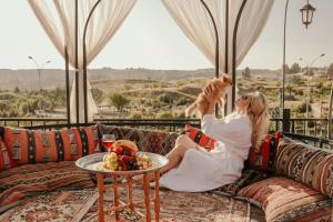 ギョレメにあるCappadocia View Suitの犬を抱くソファに座る女