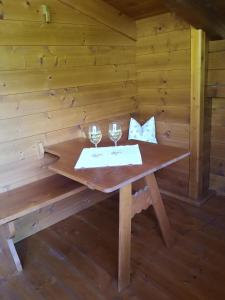 a wooden table with two wine glasses on it at Chalet Innertal in Inneralpbach