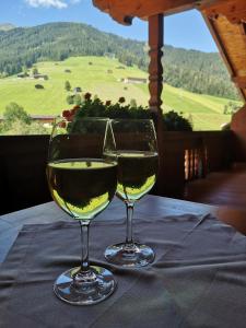 twee glazen witte wijn zittend op een tafel bij Chalet Innertal in Inneralpbach