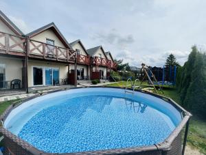 a swimming pool in the backyard of a house at Domki wczasowe "Anna" - dom wakacyjny na wyłączność 75 m2 in Mielenko