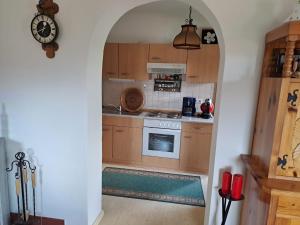 a kitchen with an archway leading into a kitchen with a stove at Kellerstöckl Berta in Eisenberg an der Pinka