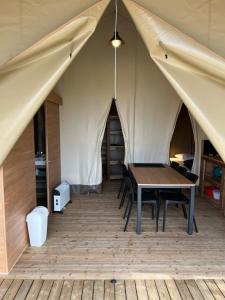 une tente avec une table et des chaises. dans l'établissement UCPA Eco Lodge, à Séné