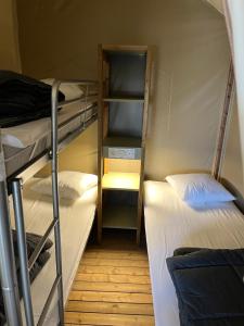 a dorm room with two bunk beds and a hallway at UCPA Eco Lodge in Séné