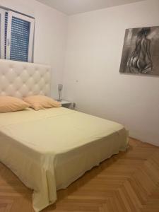 1 cama en un dormitorio con una pintura en la pared en Apartment Thomy en Medulin