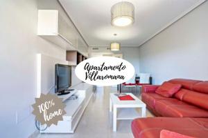 ロケタス・デ・マルにあるApartamento Villa Romanaのリビングルーム(赤いソファ、テレビ付)