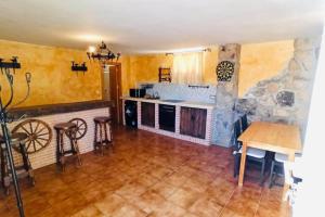 uma cozinha com uma mesa e uma parede de pedra em Casa del Río em Móstoles